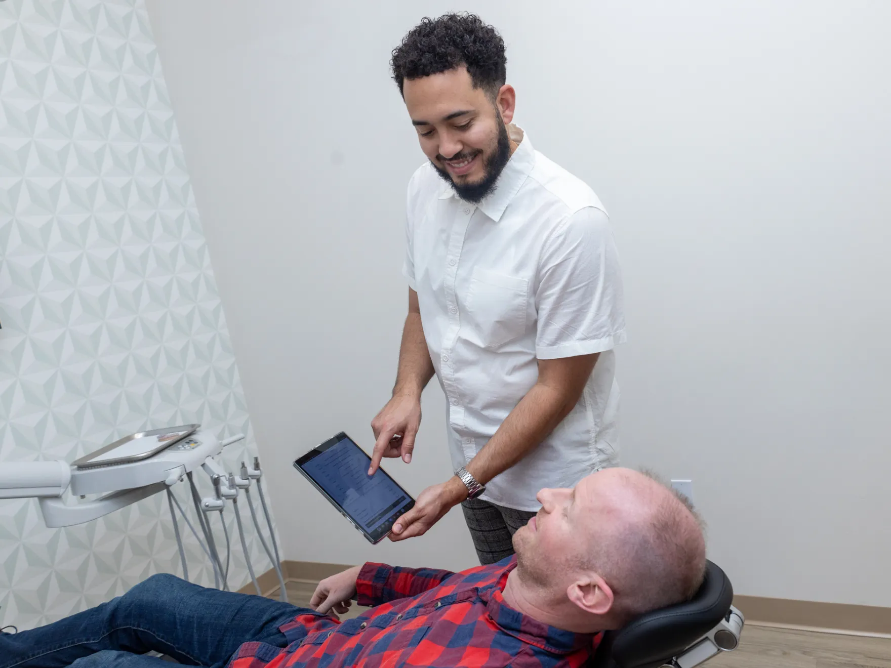 Highland Creek Modern Dentistry member showing a tablet to a patient