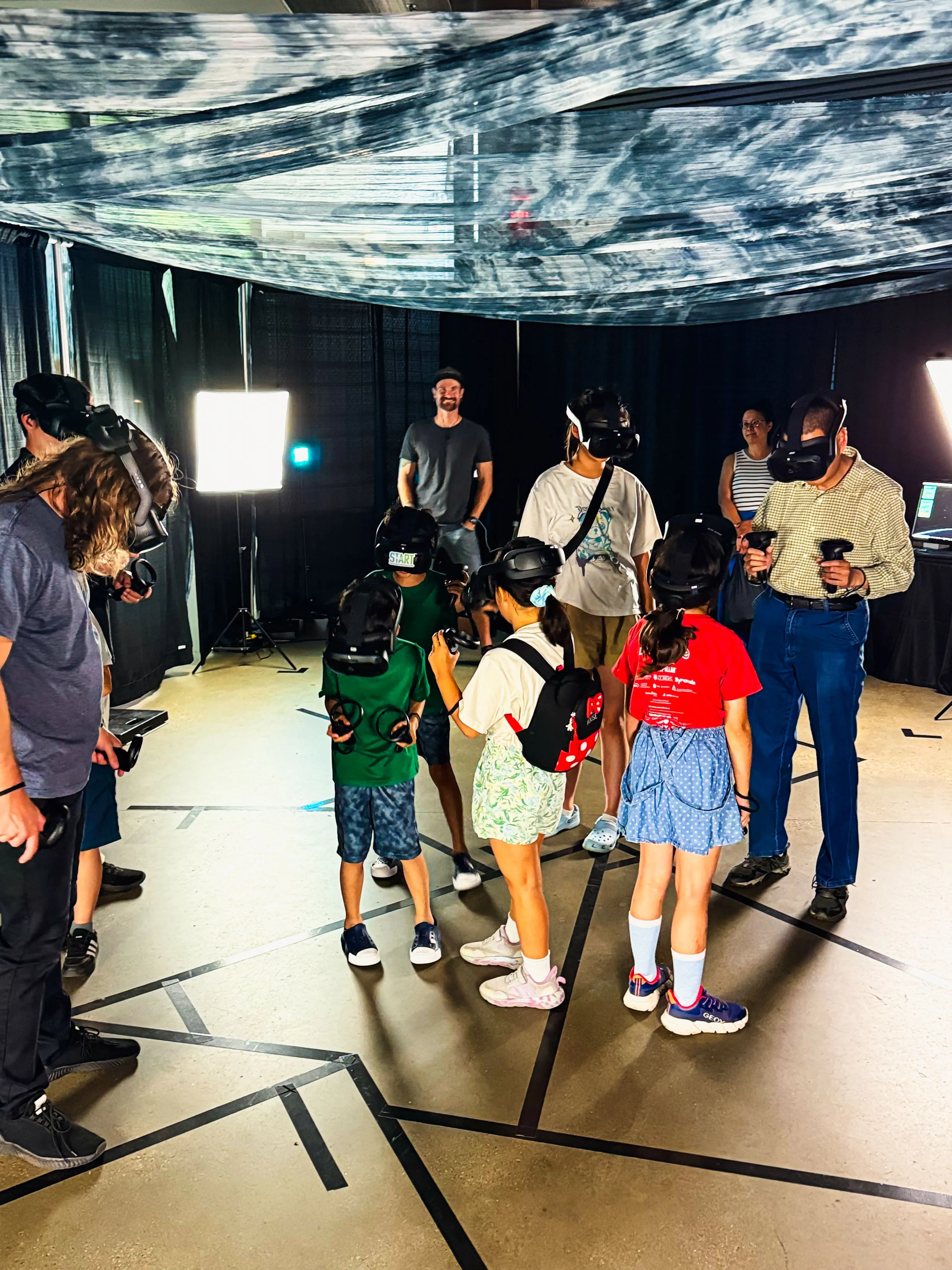 A large group of visitors in headsets during a science centre free-roam VR exhibit