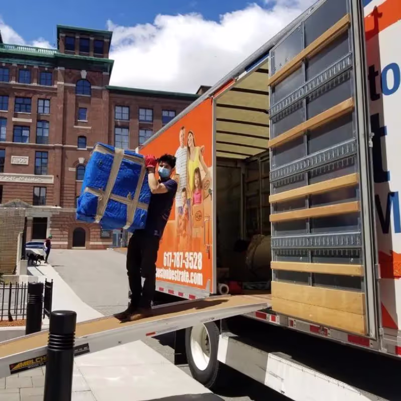 Professional movers wrapping large furniture piece for a Quincy move