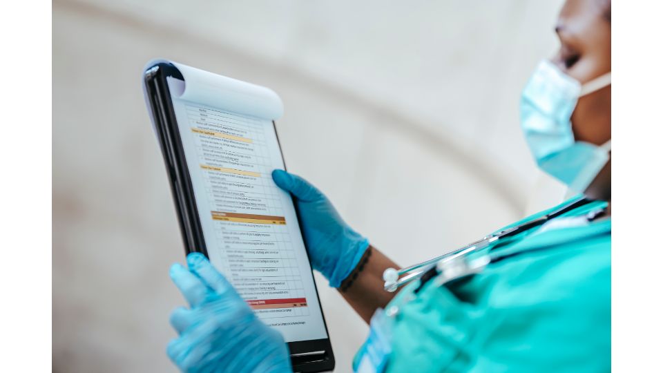 Pflegefachkraft dokumentiert Pflegeinformationen einer Patientin in der Pflegedokumentation