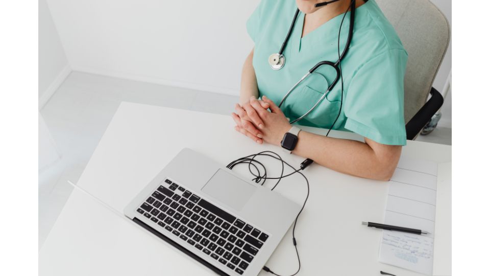 Pflegekraft sitzt am Computer und erstellt eine digitale Pflegeplanung im Rahmen des Pflegeprozesses.