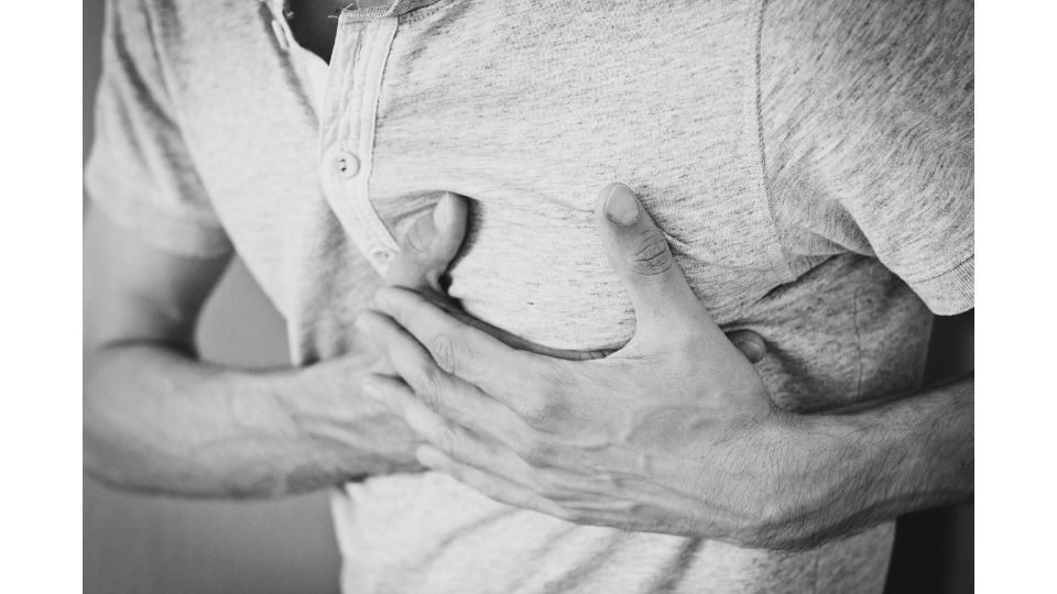 Person mit Hand auf der Brust aufgrund von Herzproblemen und Schmerzen