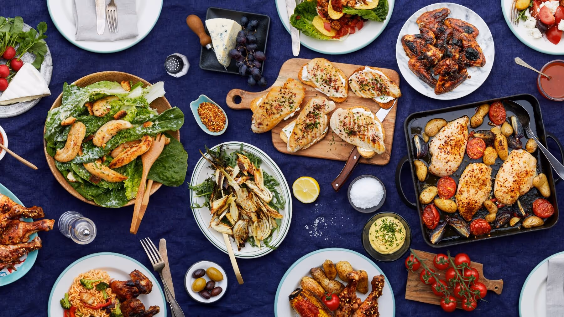 A table of food with many dishes with chicken from Guldfågeln