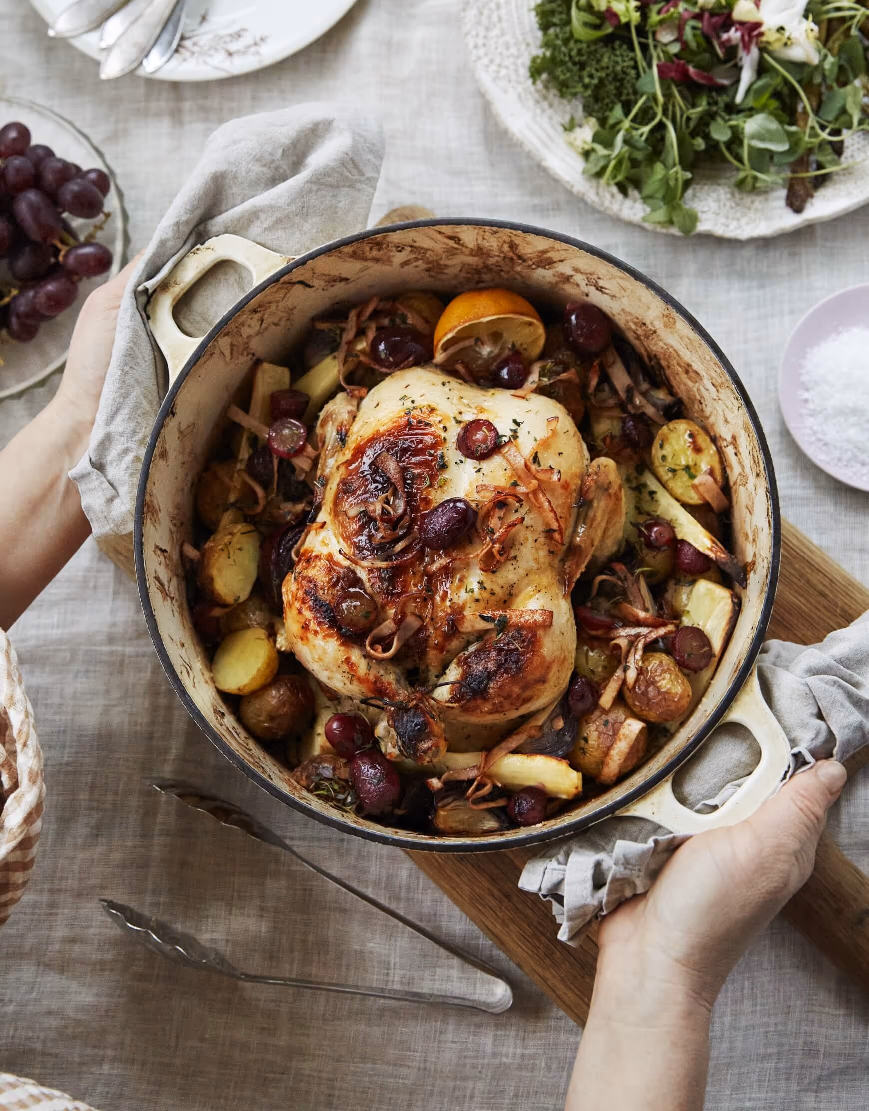 A person holding a pan with a cooke chicken from Guldfågeln