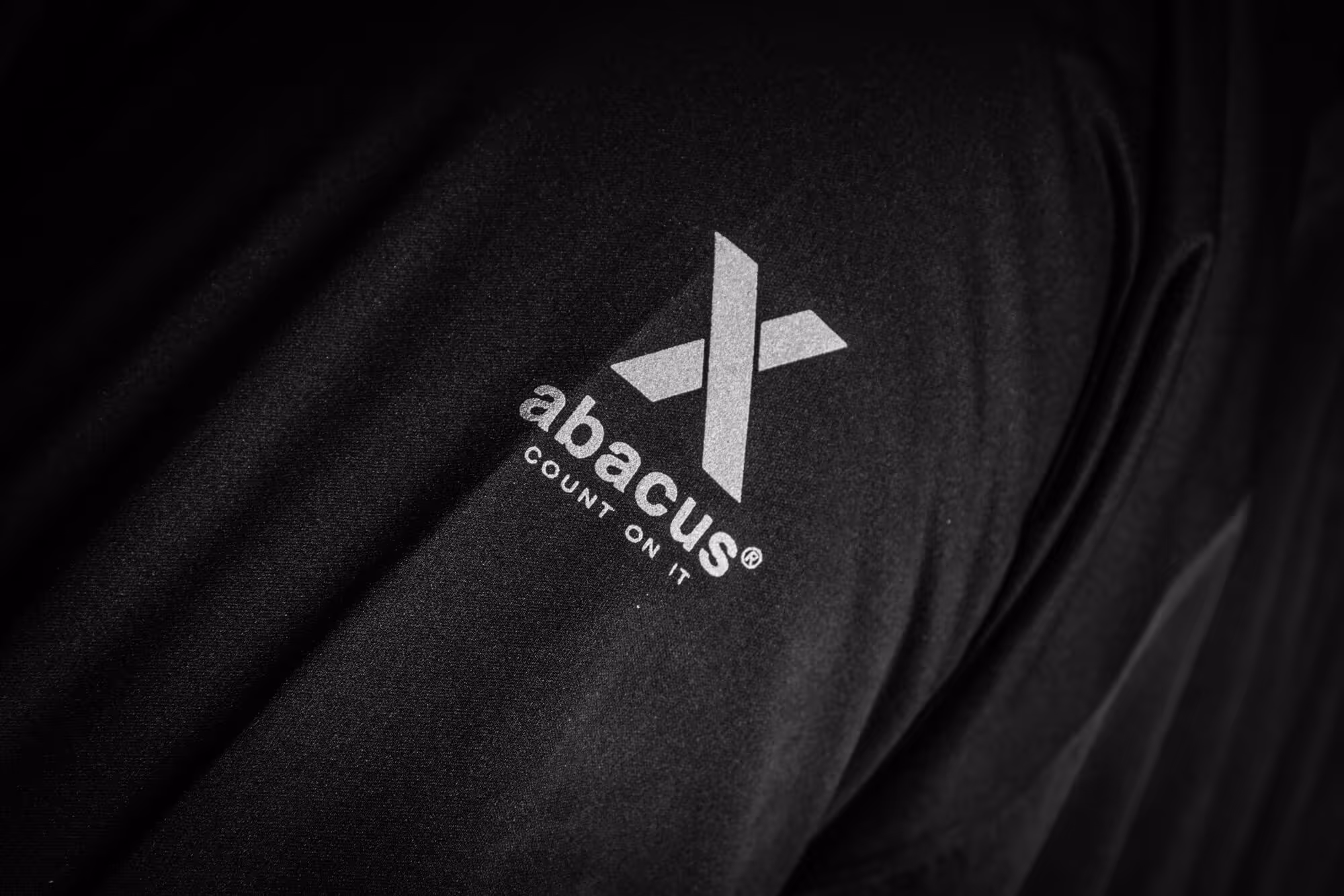 A close up photo of the logo abacus x-series on a piece of clothing