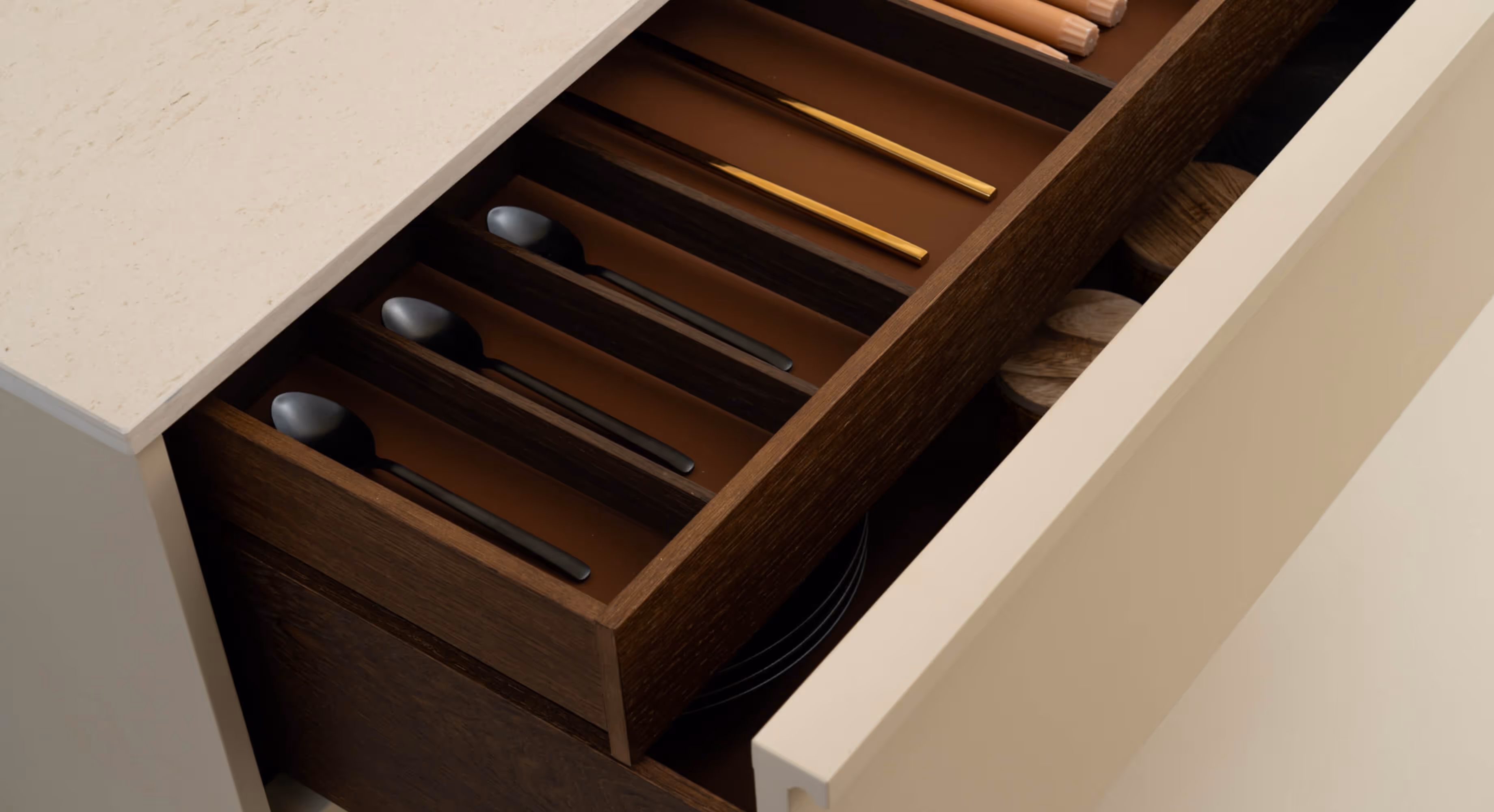 An open kitchen drawer with utensils in it.