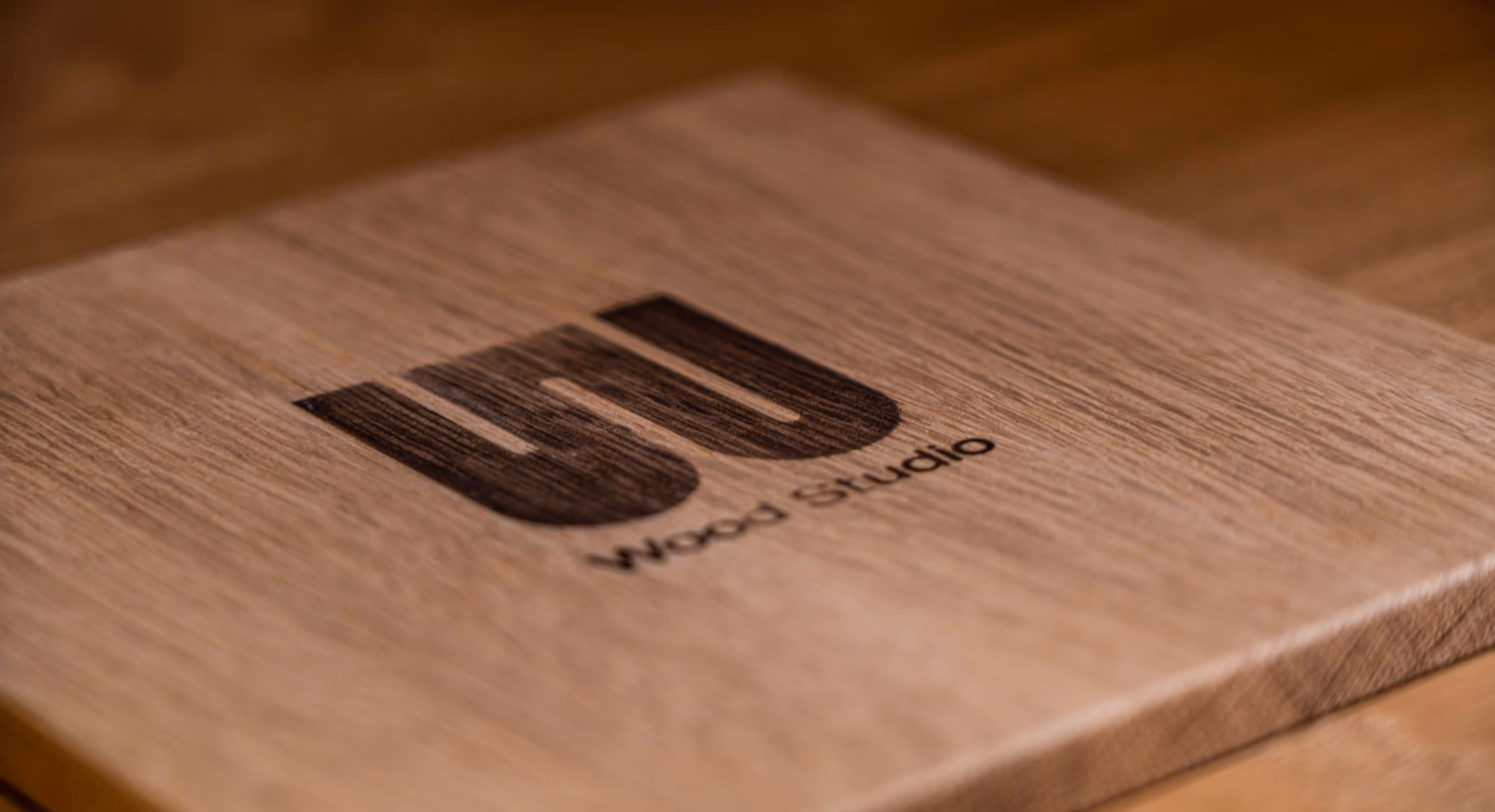 A close up photo of a piece of wood with the Wood Studio logo bruned in to it.
