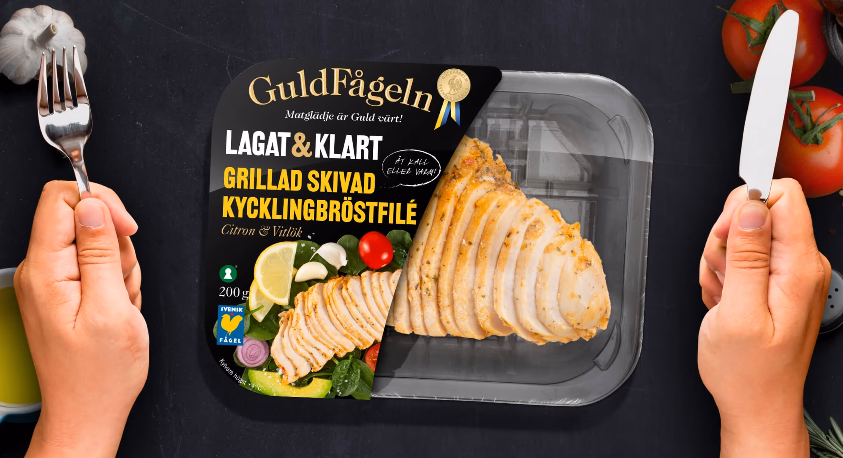Package with chicken from Guldfågeln on a table with hands holding utensils
