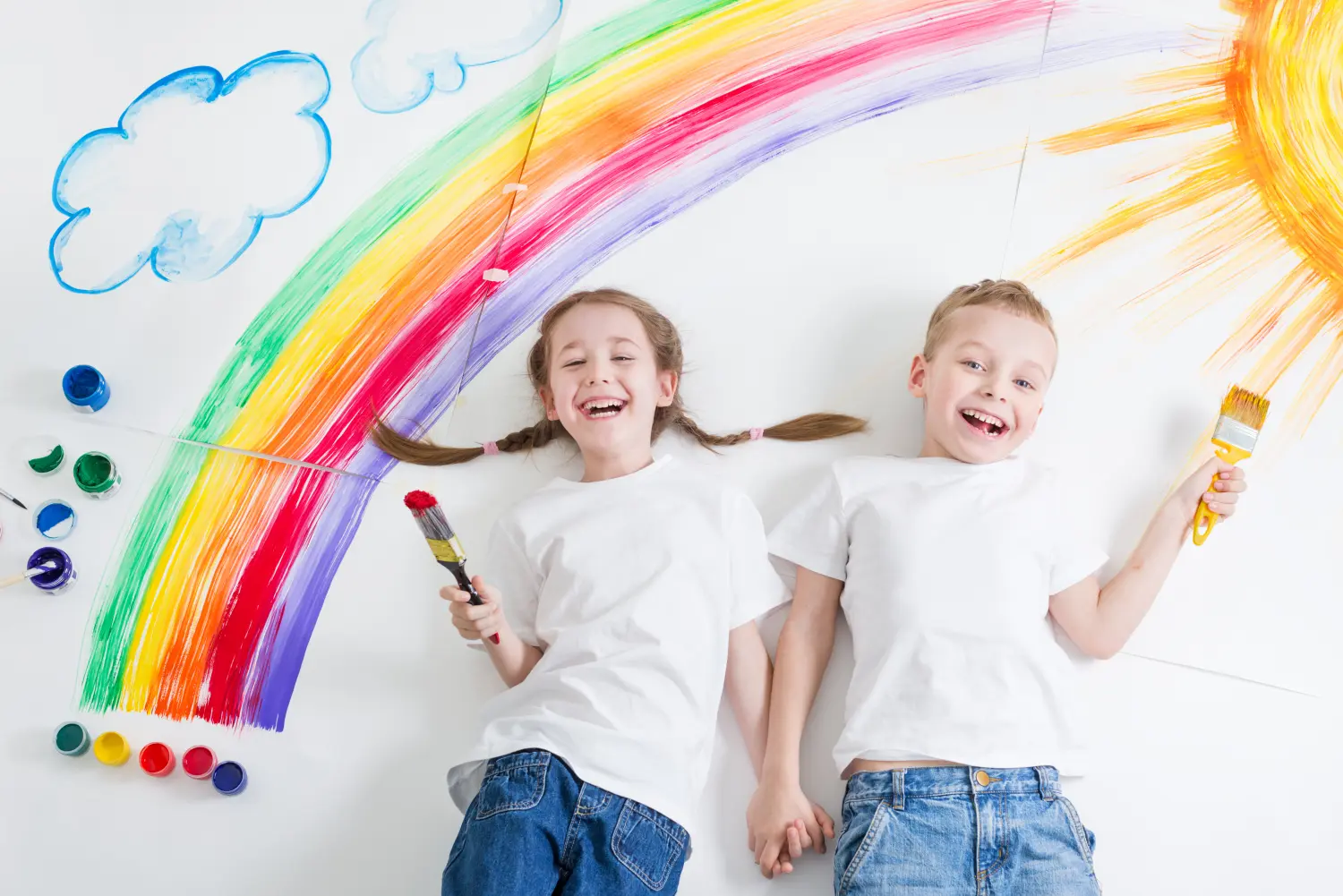 Kinder malen Regenbogen und Sonne