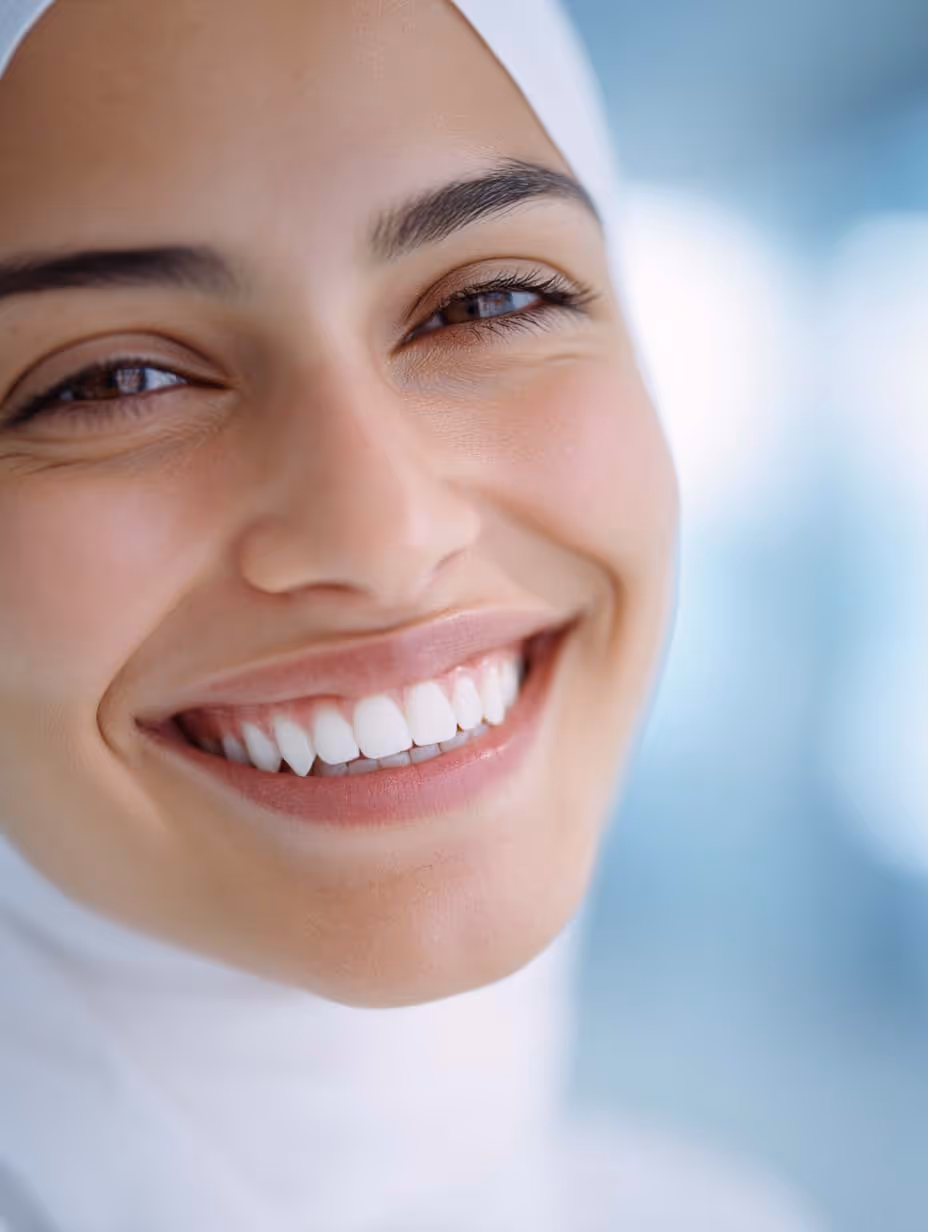 Gros plan sur une femme souriante avec des dents blanches parfaitement alignées.