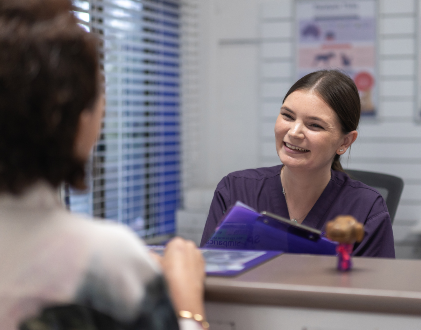 Friendly receptionist welcoming a pet owner