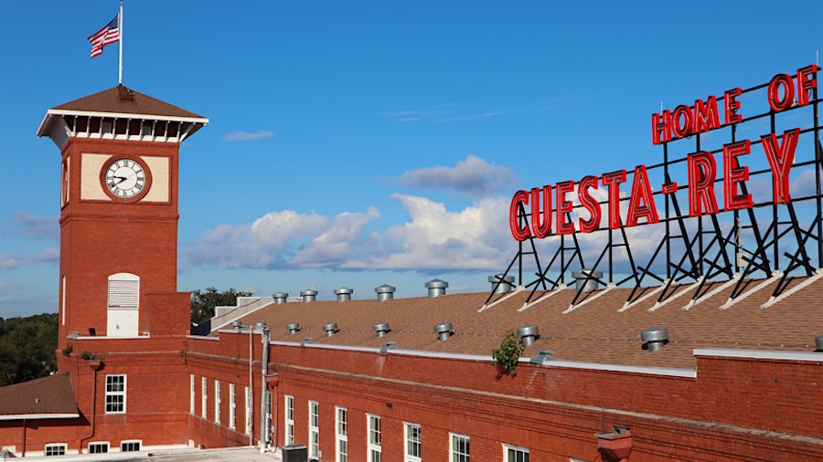 Brick building with a clock tower and "Home of Cuesta-Rey" sign.
