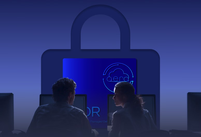 Silhouettes of two people working at computers against a large blue padlock symbol with a cloud security icon.