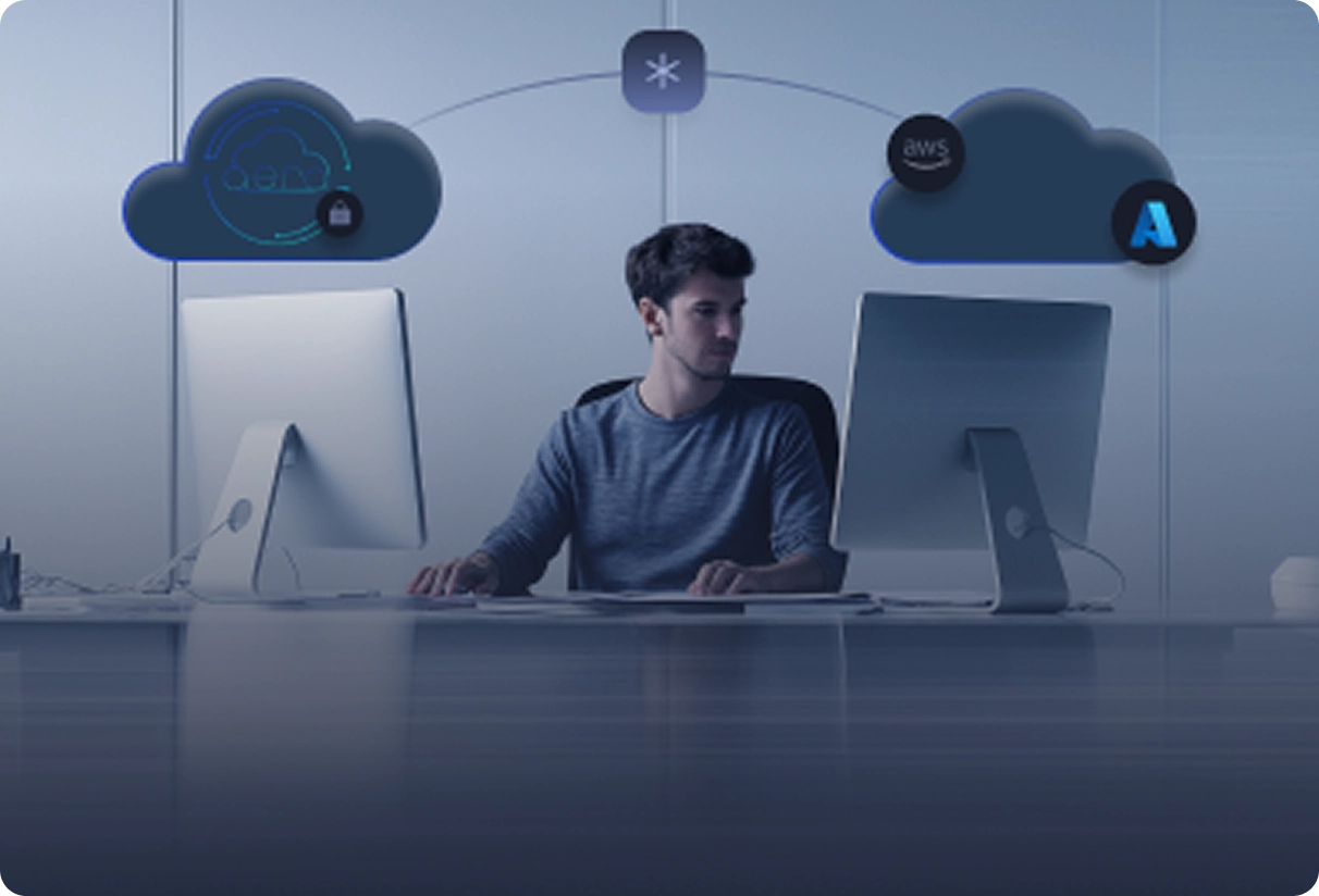 Man sitting between two desktop computers with cloud computing icons above them.