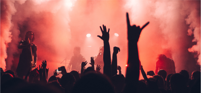 People hold their hands up in the audience at a music concert