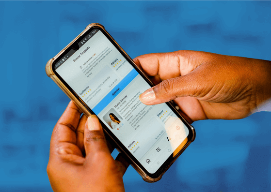 Mãos segurando um smartphone exibindo a lista de terapeutas no aplicativo da Moodar.