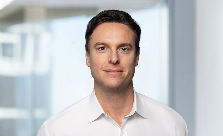 Man smiles at camera for professional headshot