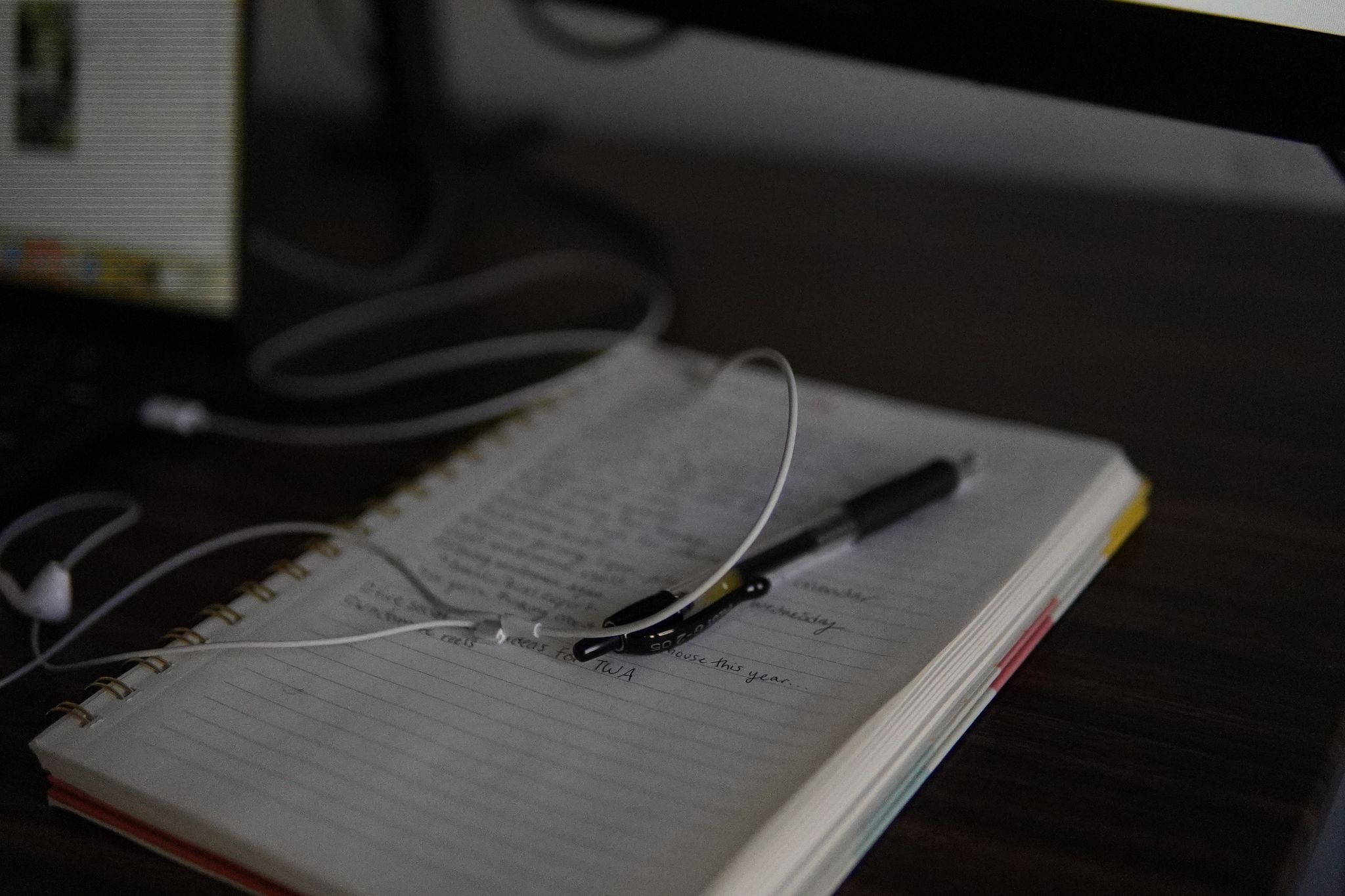 Notes on a notebook out of focus along with earphones
