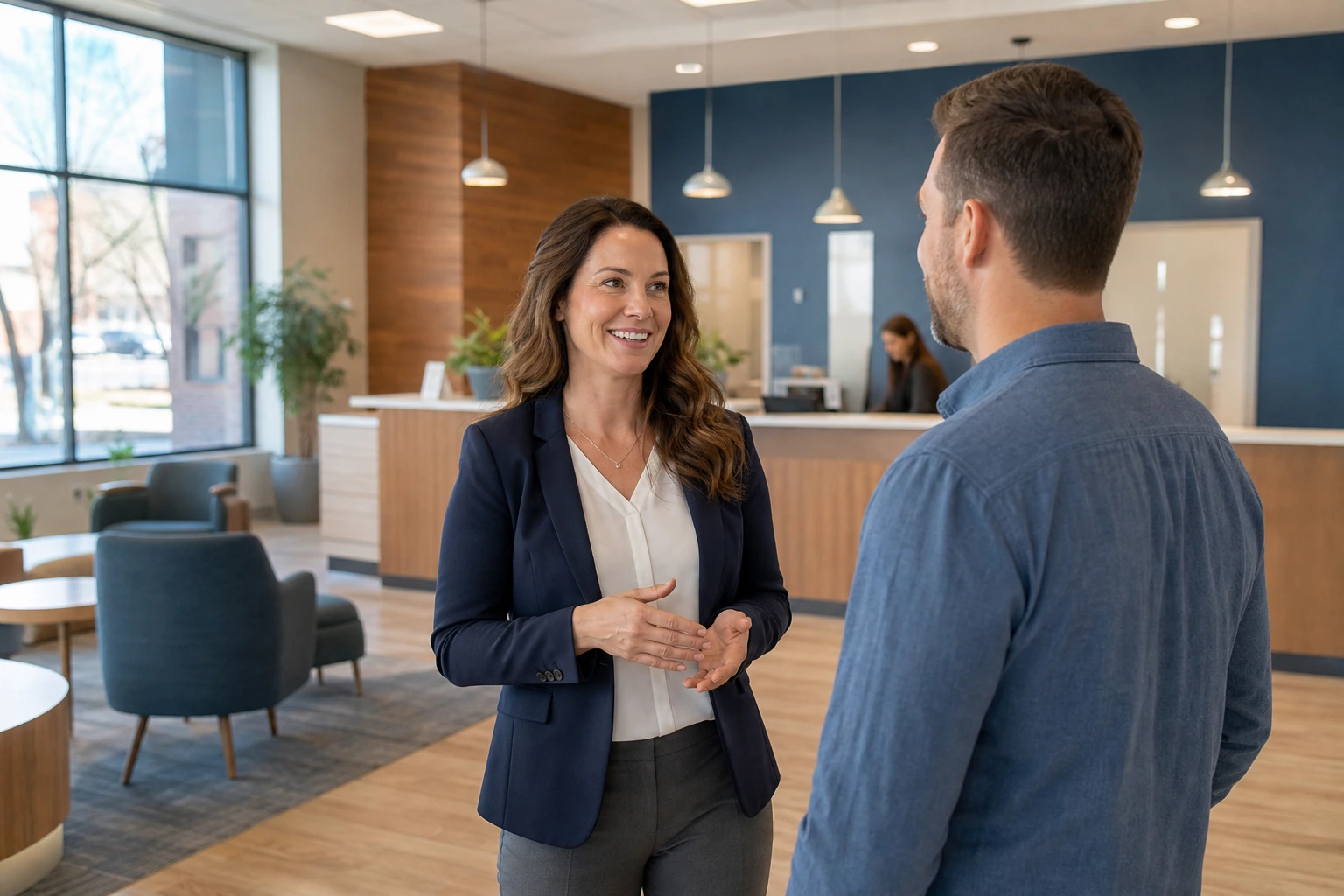 Credit union branch manager speaking with a customer in a bright community branch lobby