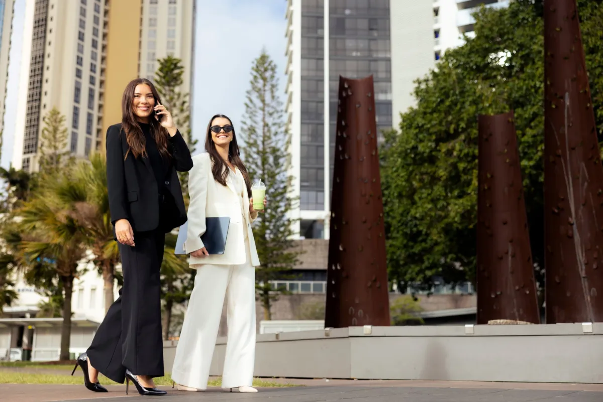 Two students in business suits walking through the city
