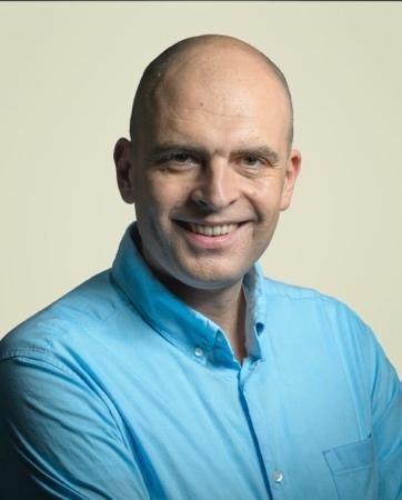 A person in a blue shirtDescription automatically generated