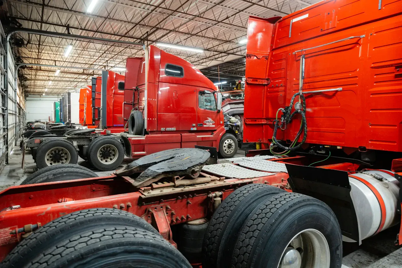 Fleet maintenance with multiple heavy-duty semi-trucks in a commercial repair facility undergoing scheduled inspections, preventive maintenance, and repair services.