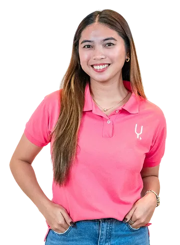 A smiling woman with long brown hair wearing Yoonet's pink polo shirt.