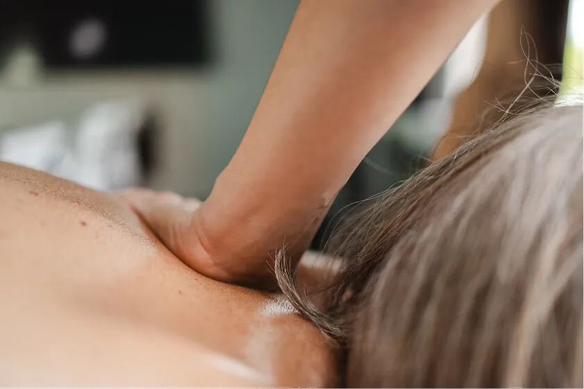 Massør giver dybdegående nakkemassage til medarbejder for at afhjælpe kontorrelaterede spændinger.