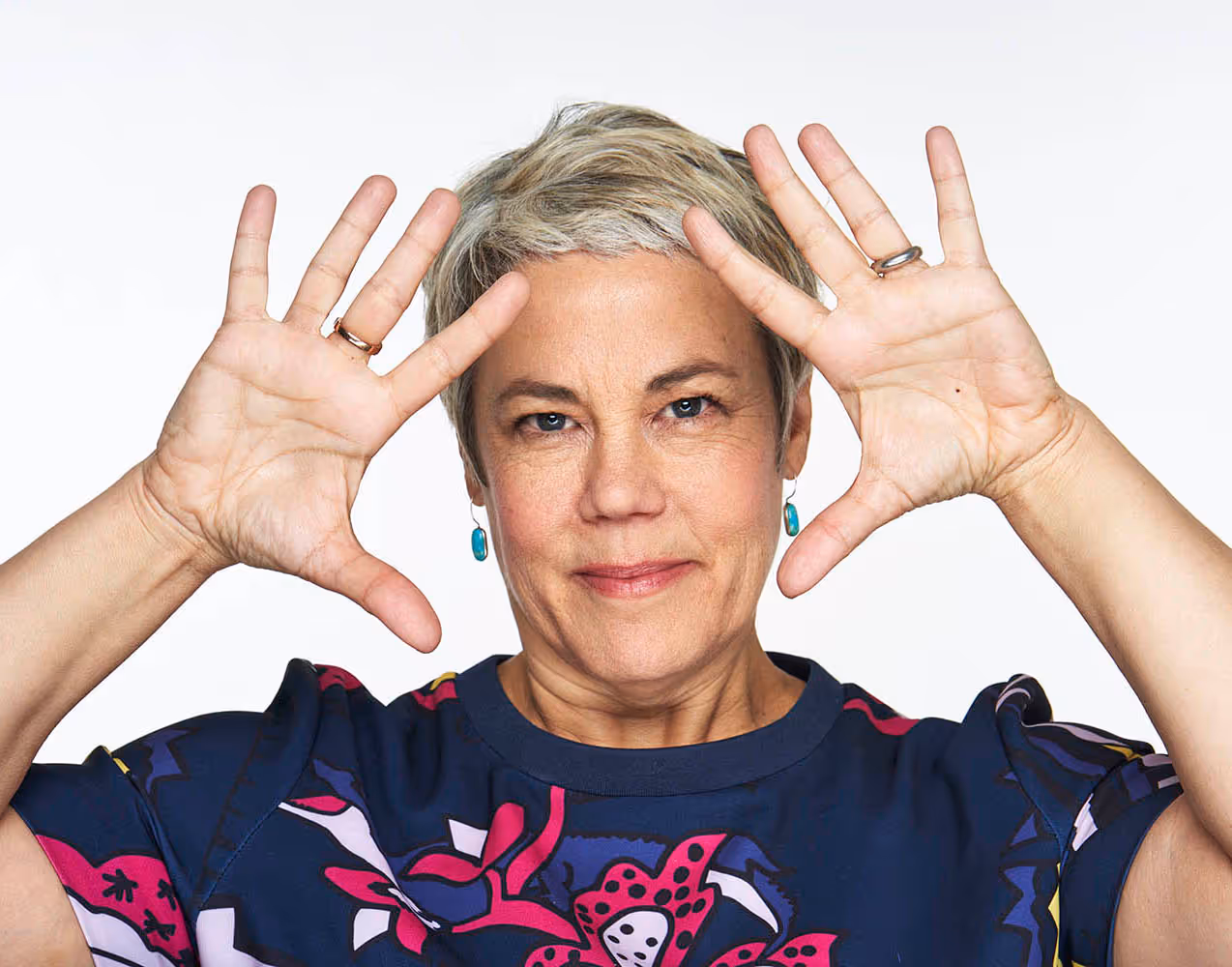 Vivian Sorenson raising her hands near her face against a plain background.