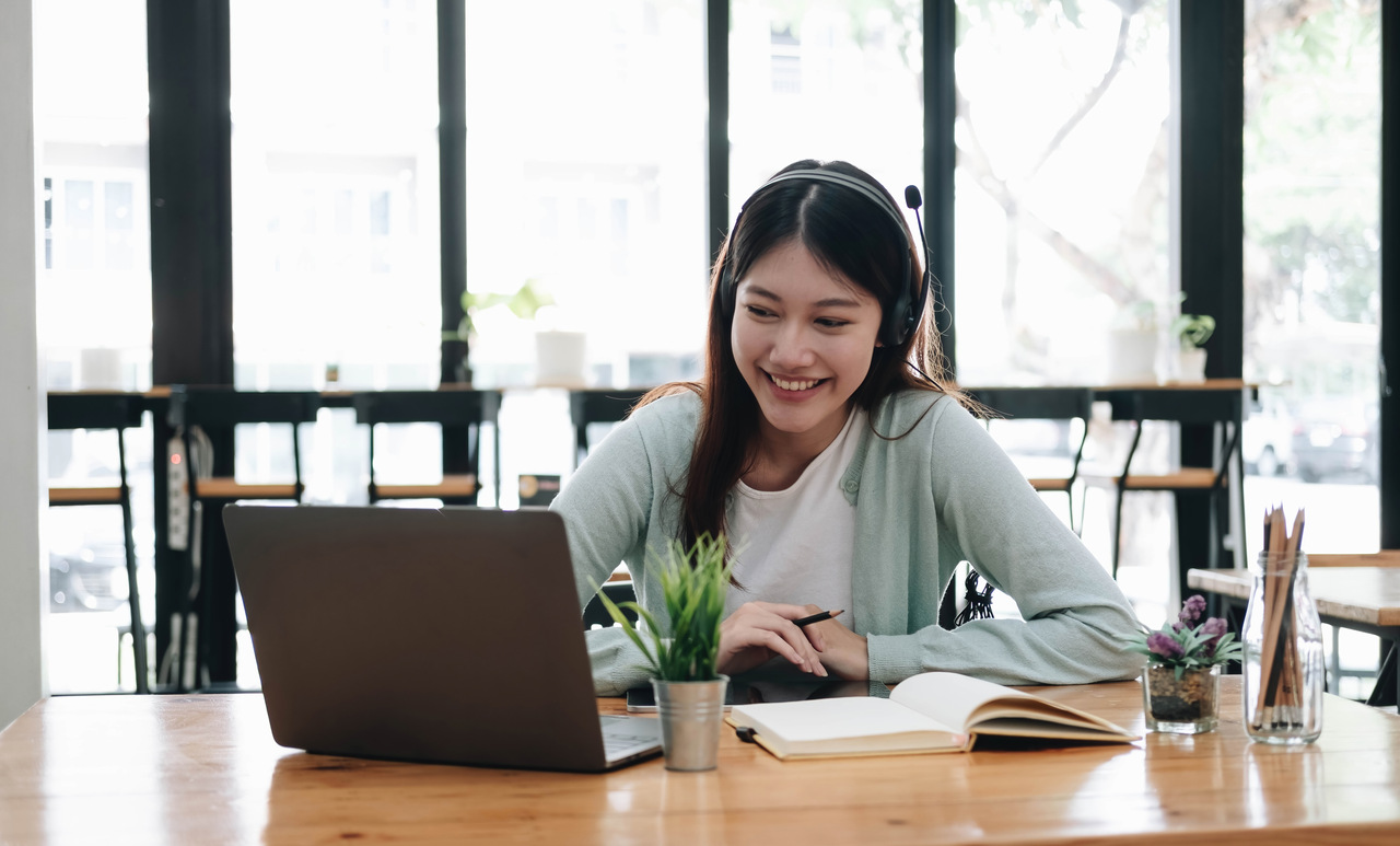 Woman wearing headphones engaged in an online learning session