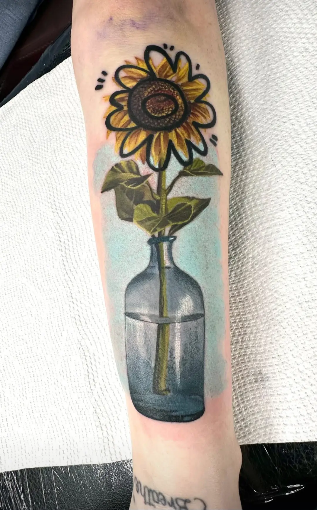 A tattoo of a sunflower in a vase