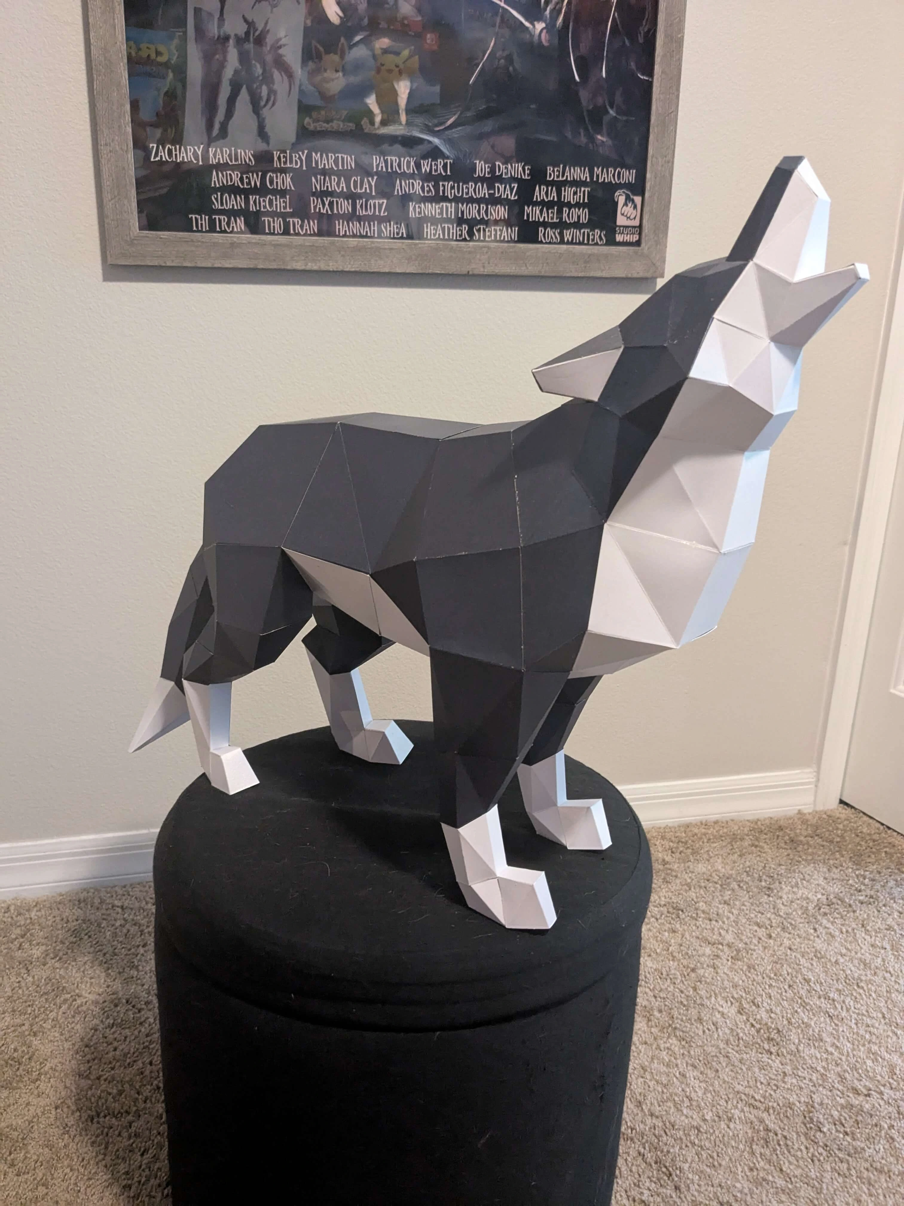 A sculpture of a geometric looking wolf on a black cushion