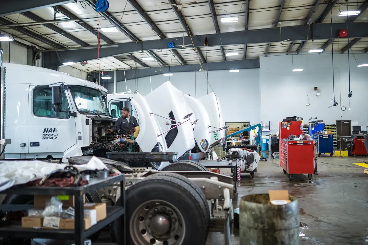 Fleet maintenance on heavy-duty commercial trucks in a full-service repair shop with technicians performing scheduled inspections, diagnostics, and preventive repairs.