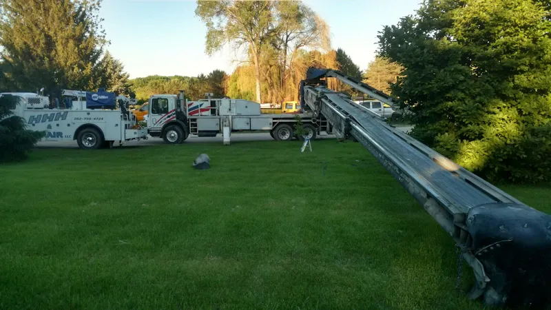 Scheduled Mobile truck repair Scheduled mobile truck repair with a boom truck extended across a lawn beside an HHH Air, LLC service vehicle.