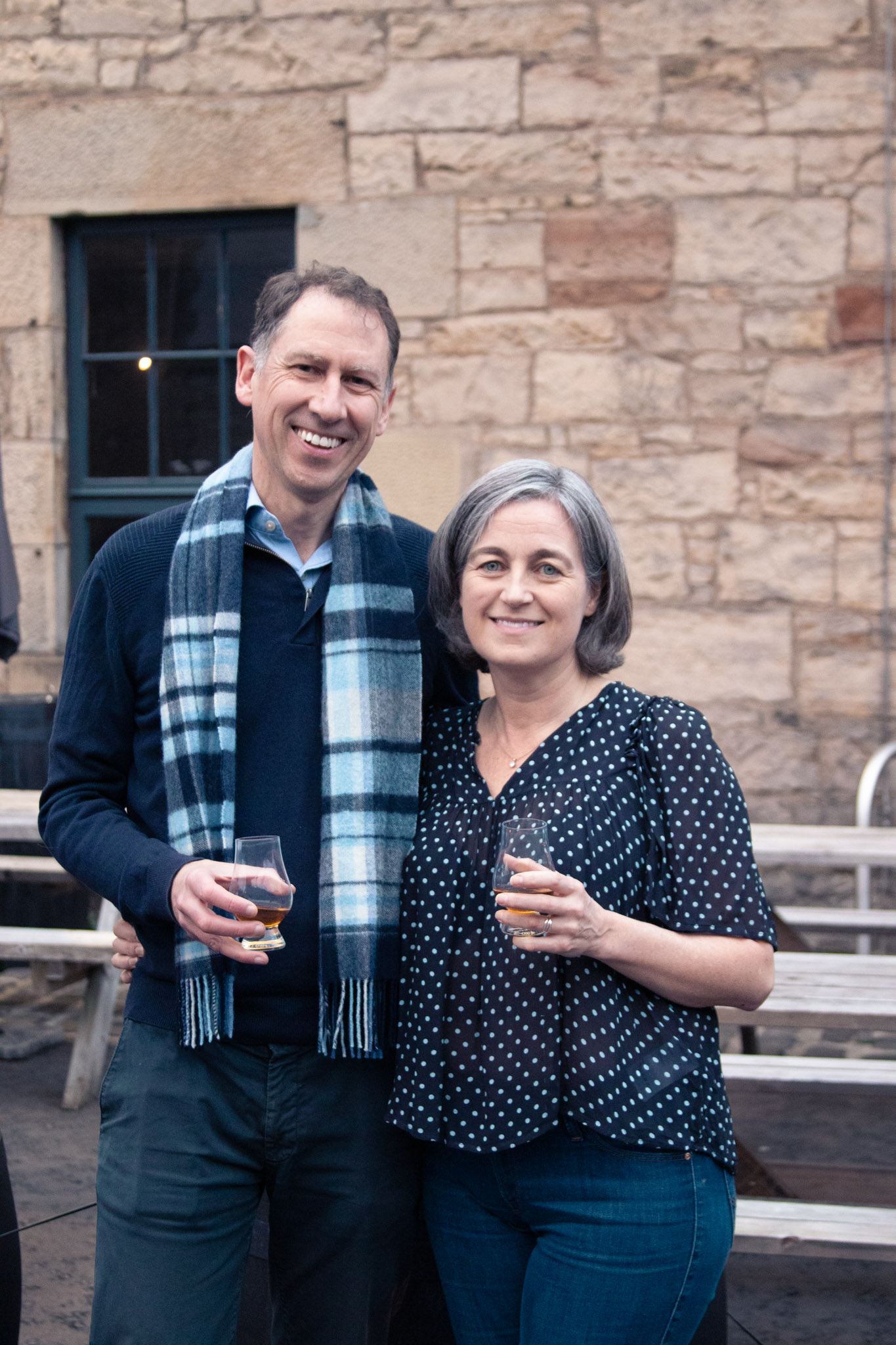 A photo of Ross and Julie posing outside a distillery.