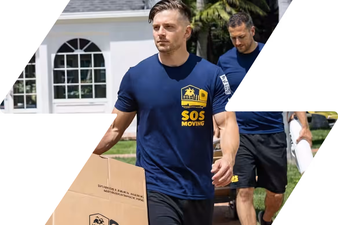 Two men wearing navy blue SOS Moving t-shirts carrying a cardboard box and a rolled-up item outdoors near a white house.