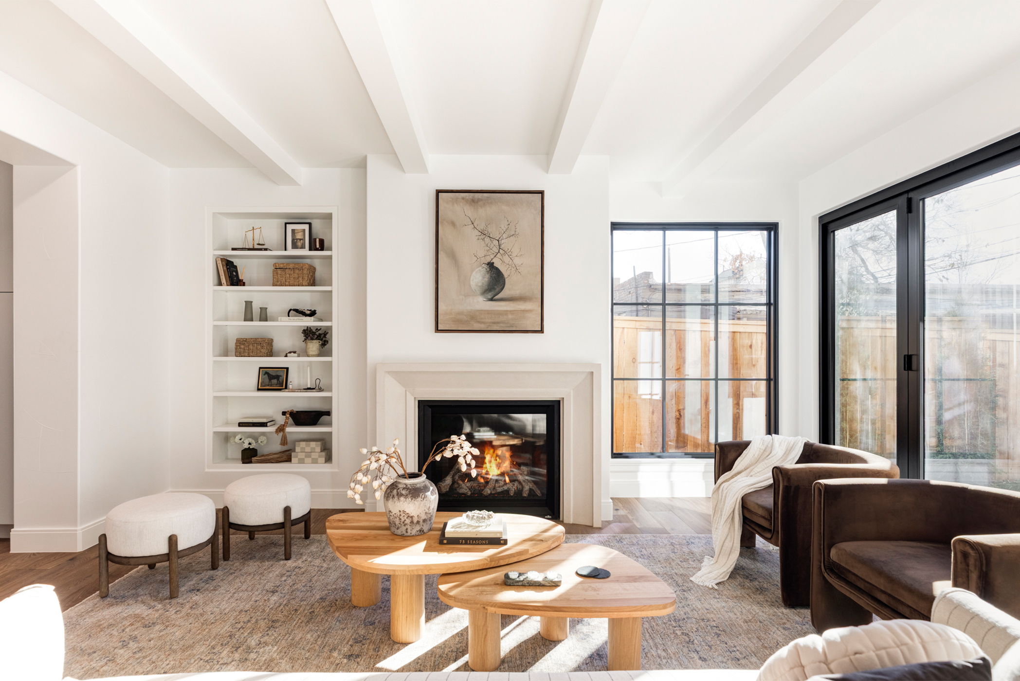 Bright living area with vaulted ceiling, fireplace, and large windows for natural light.