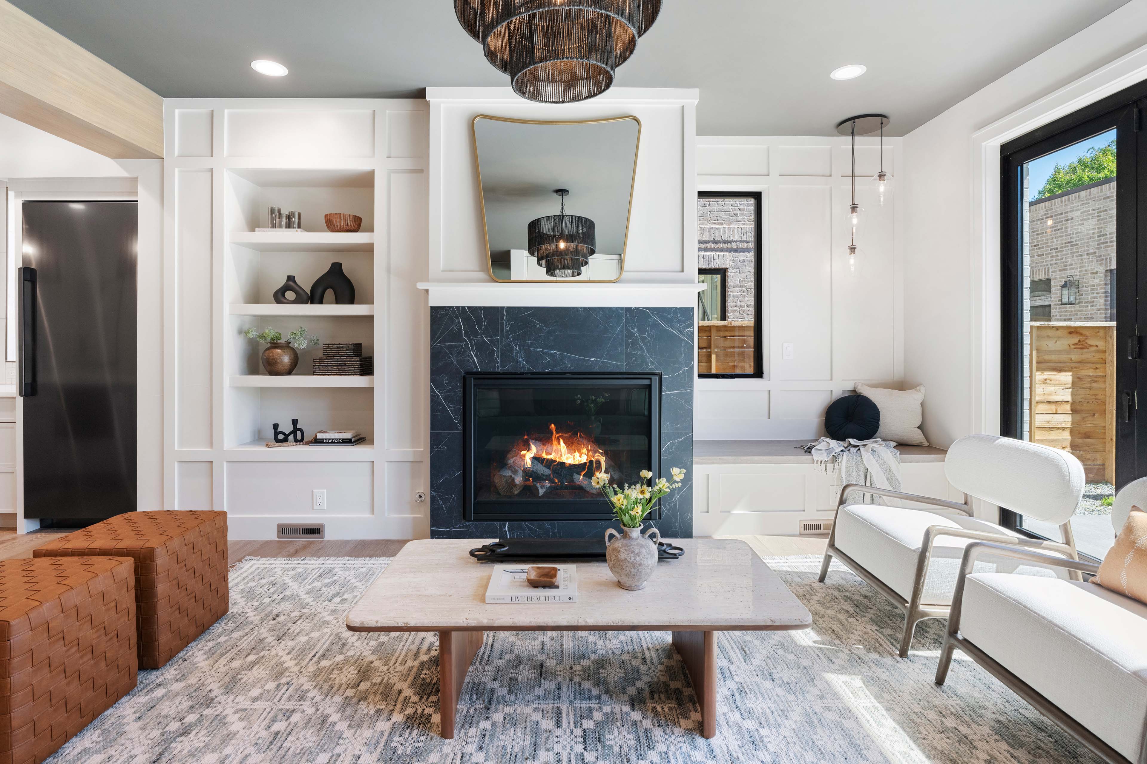 Open living room with modern fireplace, built-in shelving, and designer finishes.
