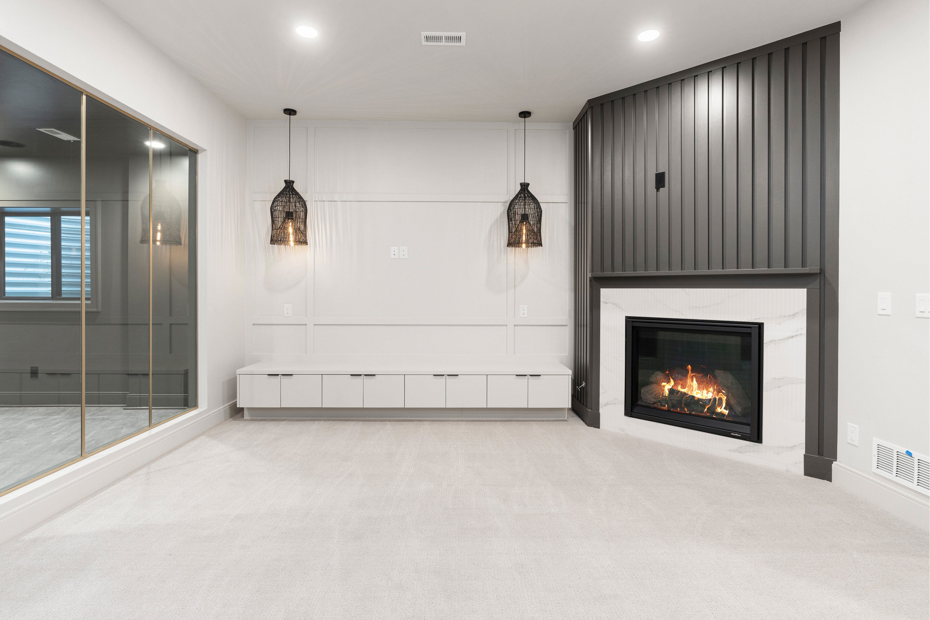 Bright basement lounge space with modern fireplace and sleek built-in cabinetry.