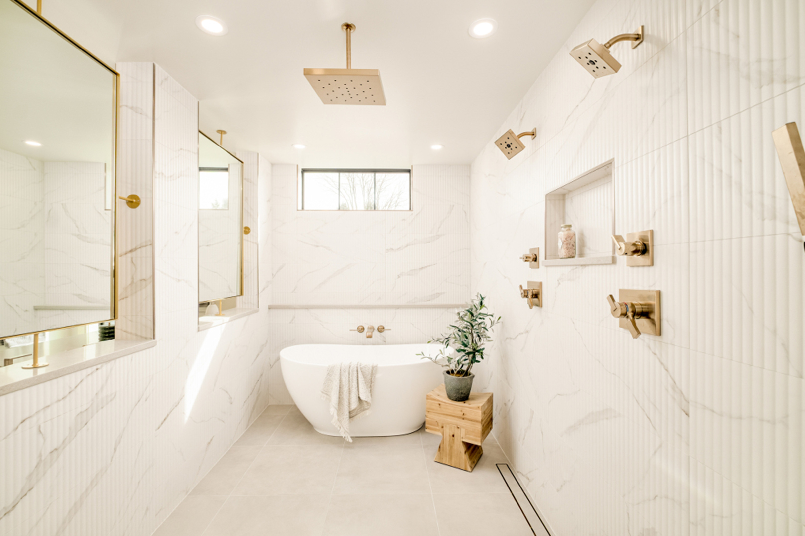 Spa-inspired bathroom with freestanding tub, walk-in shower, and brass fixtures.
