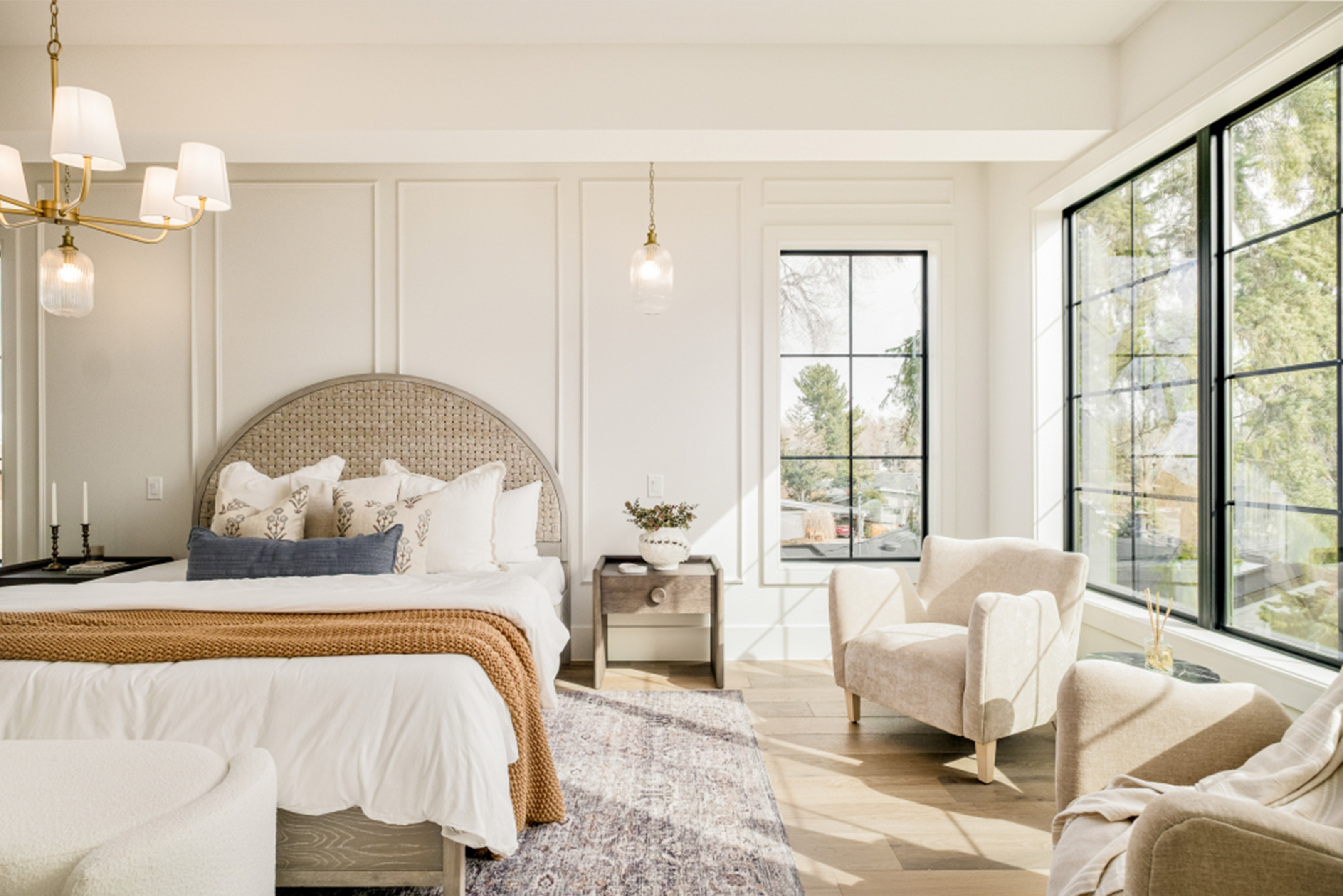 Bright primary bedroom with large windows and soft modern finishes.