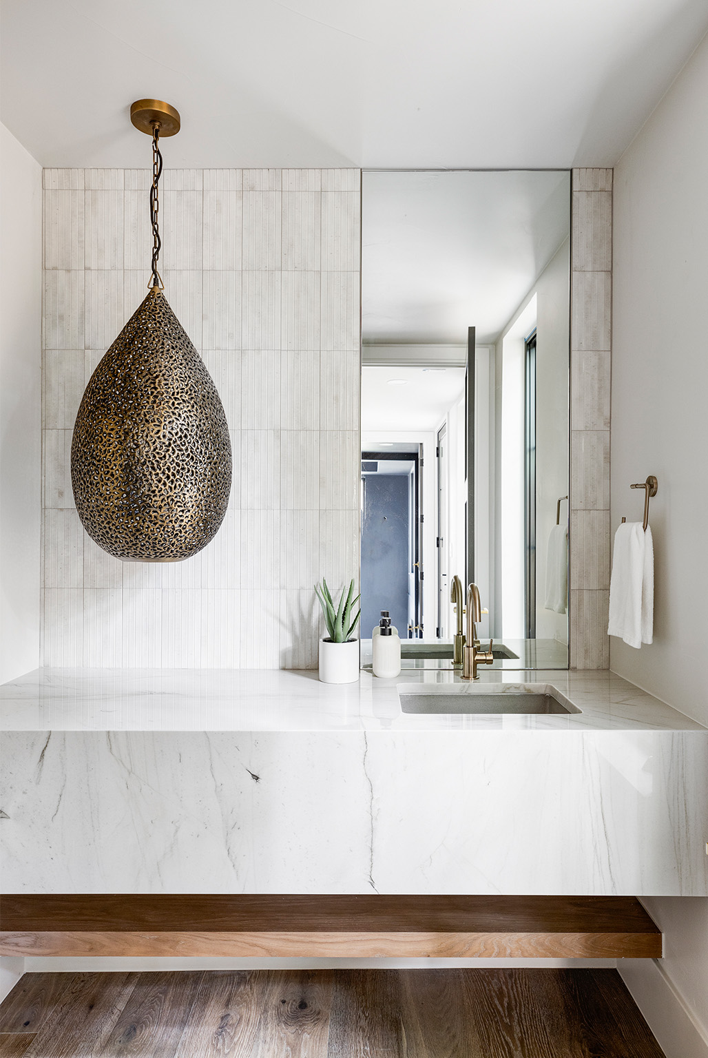 Bright spa-inspired bathroom with freestanding tub and modern pendant lighting.