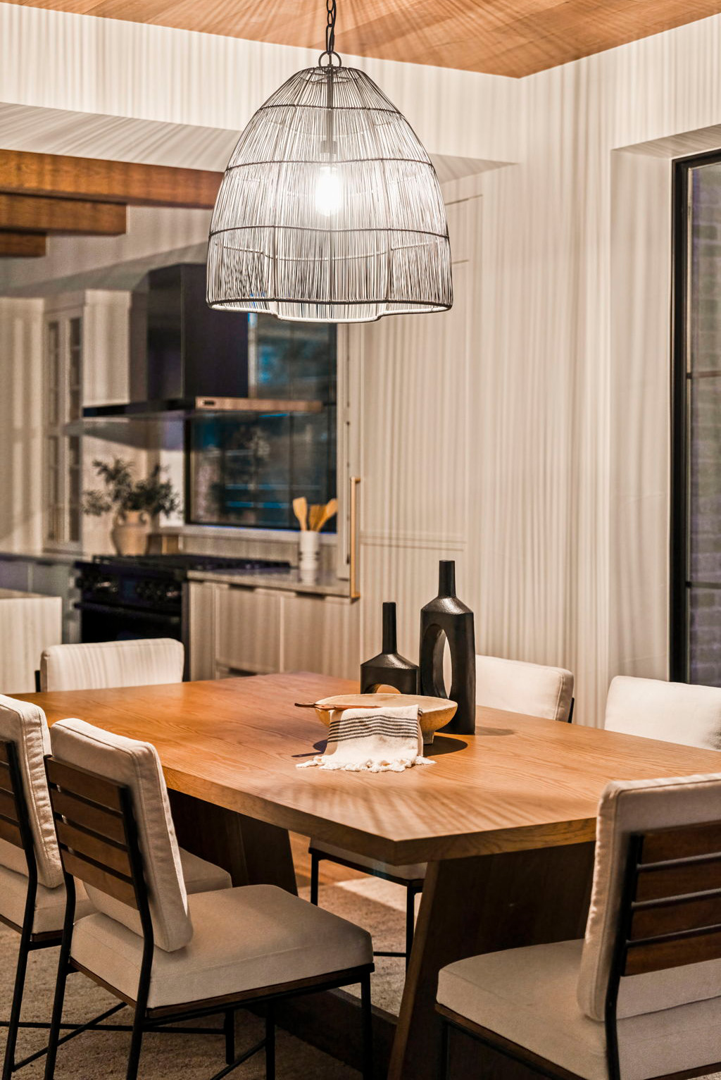 Contemporary dining nook with warm wood tones and statement pendant light.