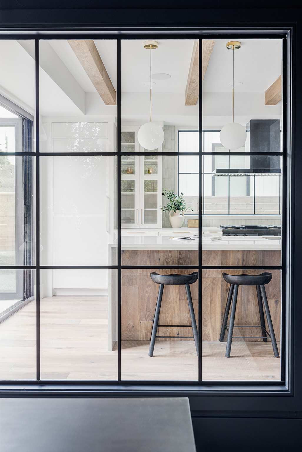 Black-framed modern glass doors opening into a contemporary dining area.