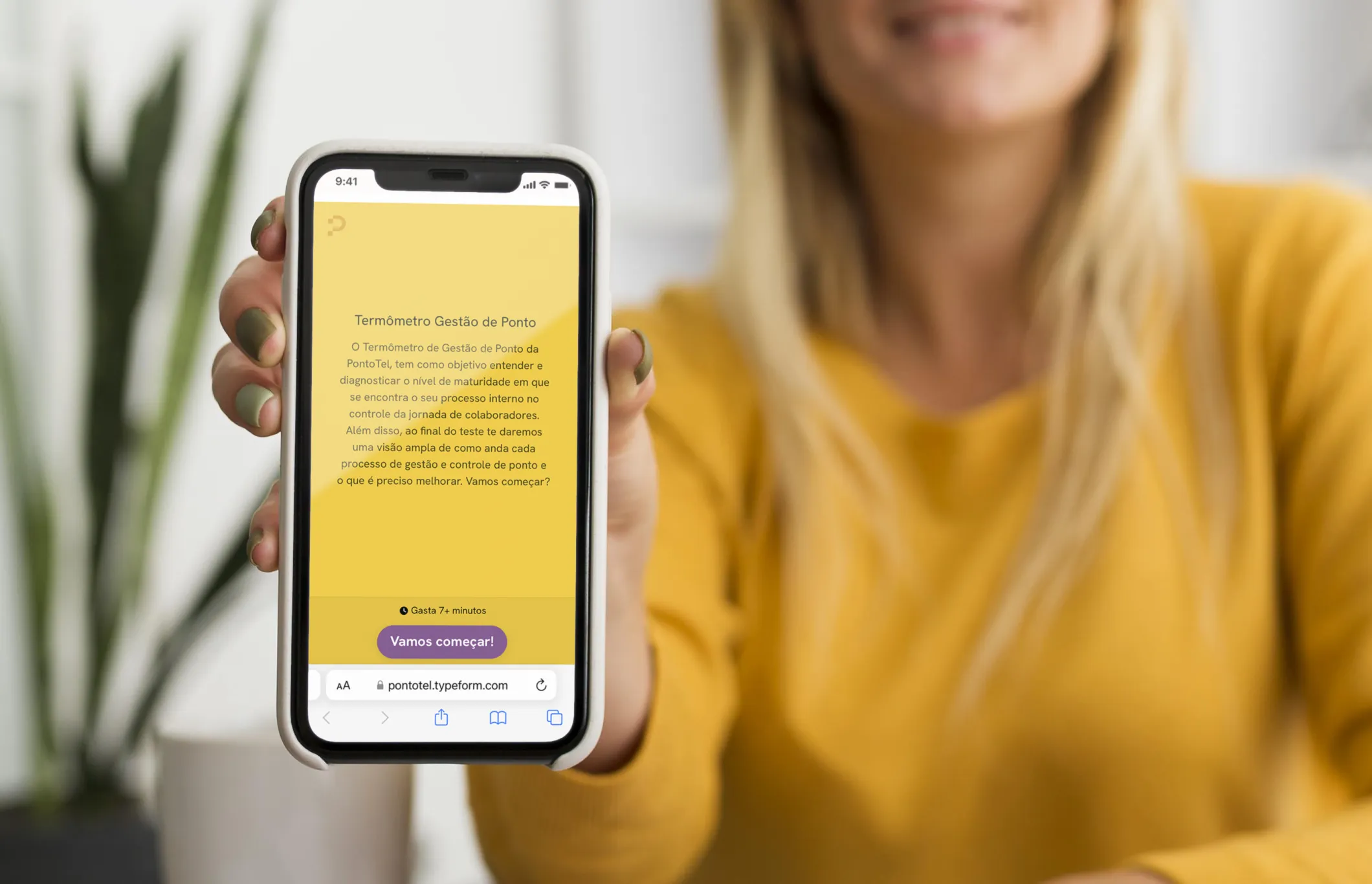 Mulher apresentando tela de celular com texto de blog