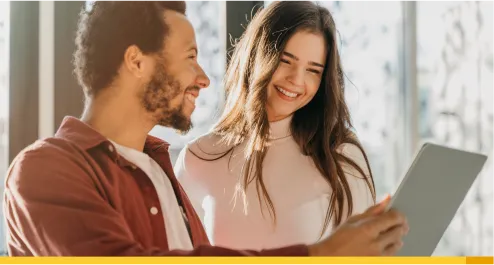 Homem segurando um tablet ao lado de uma mulher sorrindo