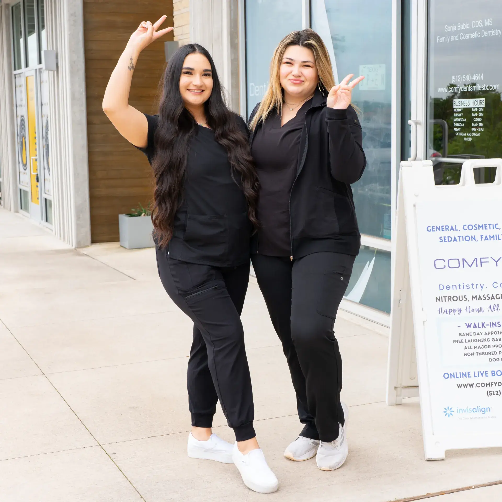 women standing doing peace and love sign