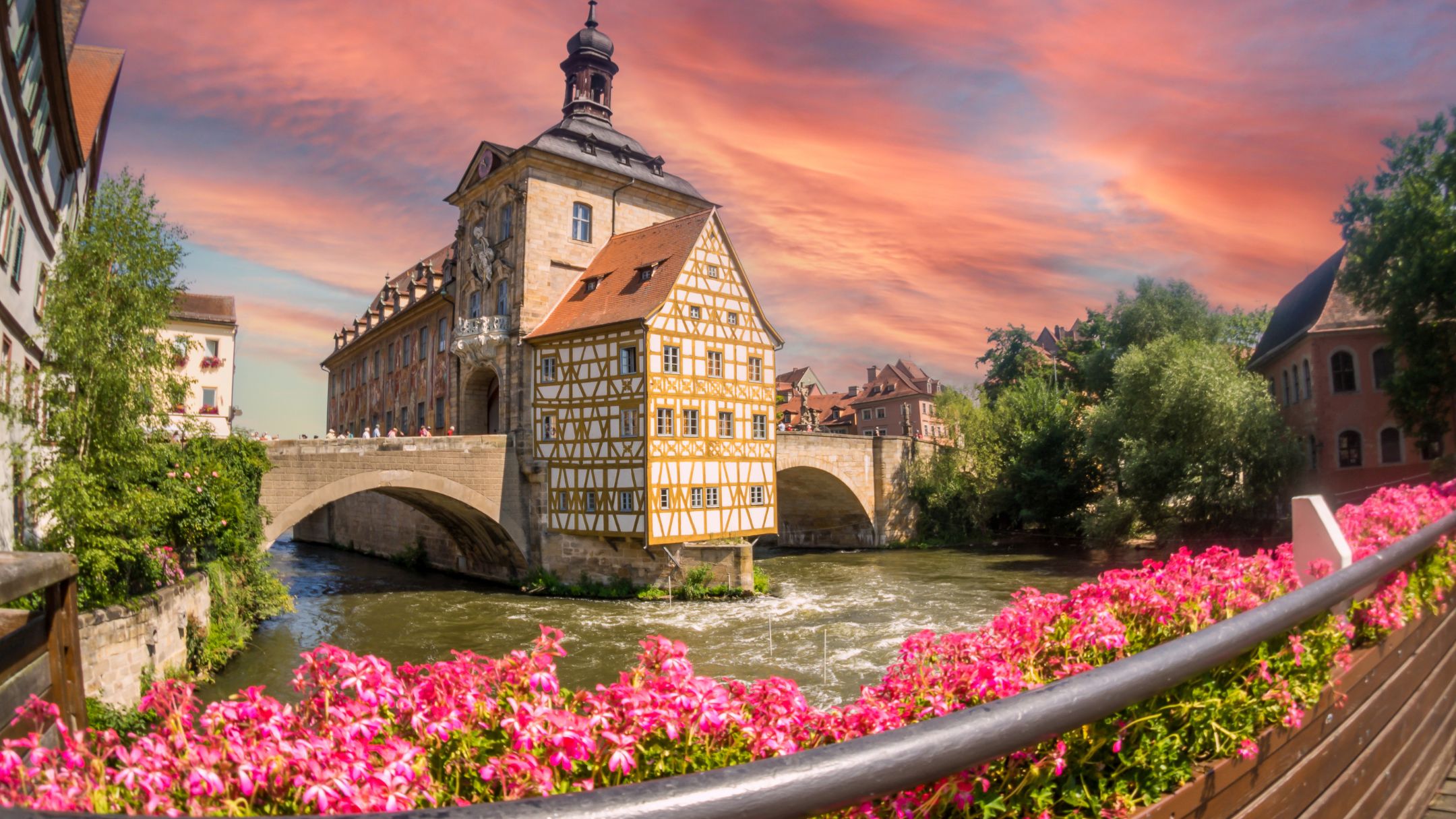 Historisches Fachwerkhaus mit Blumenbeet im Sonnenuntergang in Bamberg.