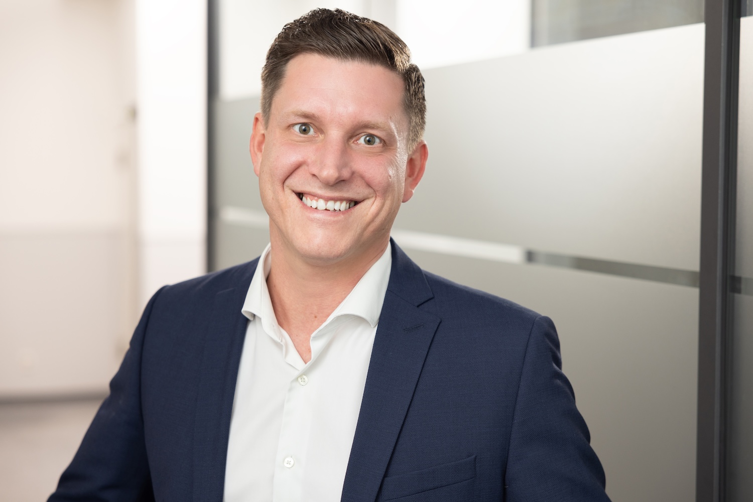 Mann im blauen Sakko, leicht lächelnd