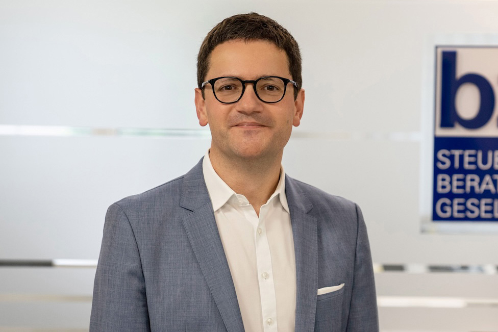 Mann mit Brille steht vor bzp-Schild